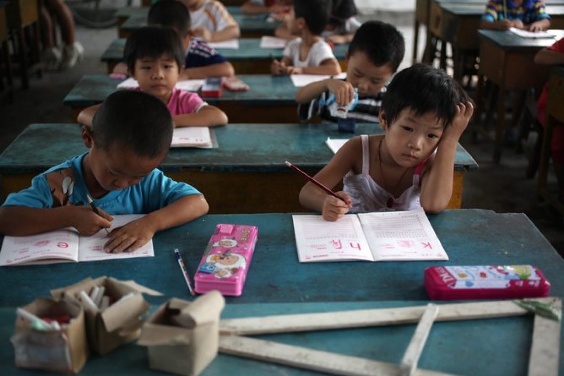 epa02877943 Kindergarten students writing in their workbooks in a class in Dongba Experimental School, a school for children of migrant workers on the outskirts of Beijing, where the school term has started early as a forced closure looms in China on 23 August 2011. The Dongba Experimental School is one of more than 20 schools for children of migrant workers that were deemed 'unsafe' that has been ordered to shut down by the authorities in Beijing, forcing thousands of students to scramble for alternative schools. The school, which has been operating for the past 11 years, started its new term two weeks earlier than usual in a bid to prevent the school from being demolished. Yang Qin, the school's principal, said local officials have even gone as far as to stop their water and electricity supply, forcing the school to rent a generator and and transport water using a water cart from parents' homes in the neighbourhood. Embittered parents cite long distances and the lack of transport for alternative schools and many even face the grim prospect of separating from their children and sending them back to schools in their hometowns in other provinces. Some have taken on a wait and see attitude hoping the school will not be closed down while others have asked the school to refund school fees of 800 RMB (86euros) for the term. Migrant workers in Chinese cities are generally poorly educated and are subjected to various difficulties of low pay, inadequate social security, and discrimination, mainly due to a hereditary household registration or 'hukou' system that divides the population into urban and rural residents and limits migrants access to urban services like state education.  EPA/HOW HWEE YOUNG